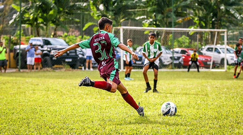 Jovens atletas em partida de futebol de base